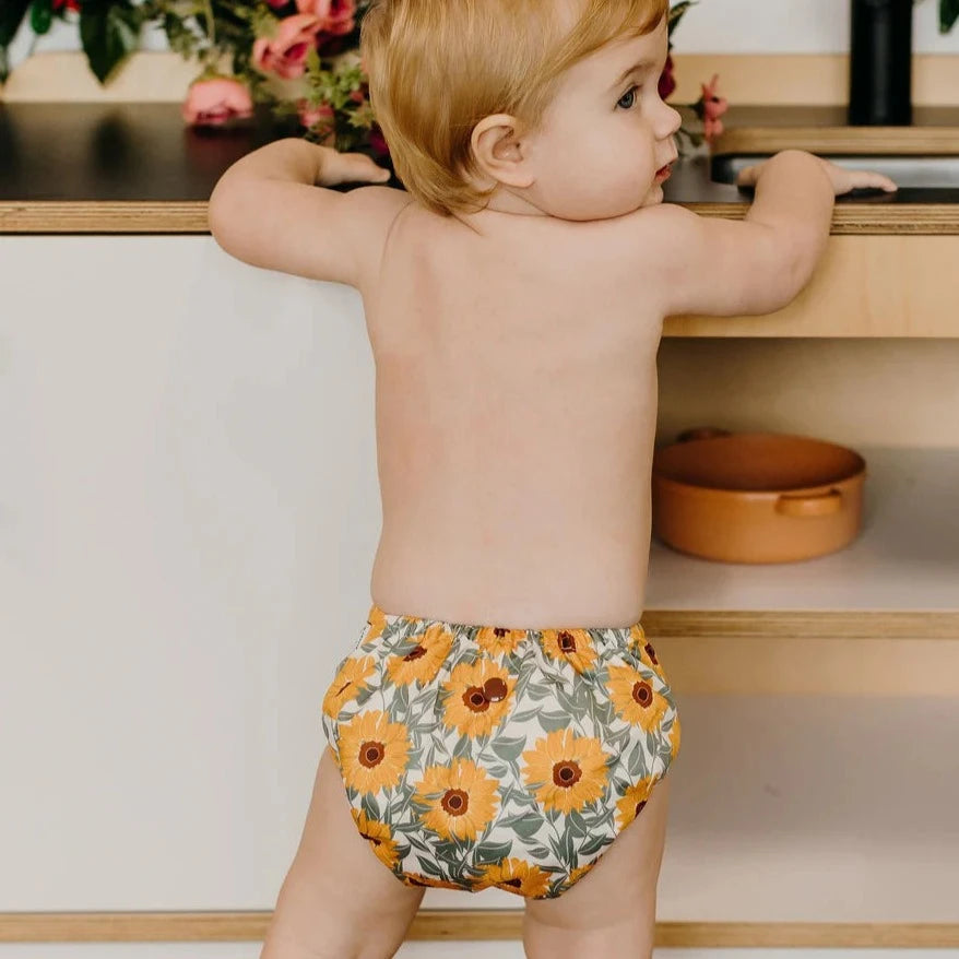 reusable nappy with sunflowers on a toddler standing
